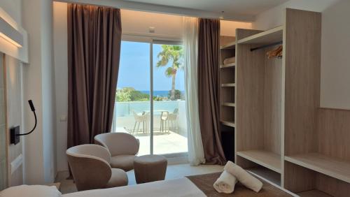 a hotel room with a bedroom with a view of the ocean at Lago Playa in Es Pujols