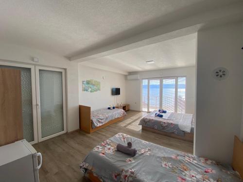 a bedroom with two beds and a large window at RISTESKI GUEST HOUSE in Ohrid