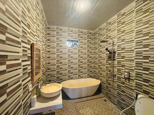 a bathroom with a tub and a toilet and a sink at pondok ubud nia cahya in Tegalalang