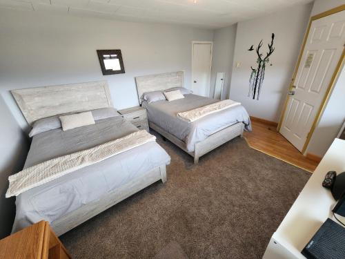 a bedroom with two beds and a door at Misty River Lodge - in Radium Hot Springs