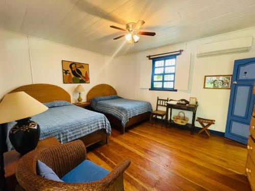a bedroom with two beds and a ceiling fan at La Posada Azul Boutique Hotel Coco SA in San Juan del Sur