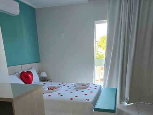 a room with a bed with a red heart on it at Residencial New Stilo-Falésia in Canoa Quebrada