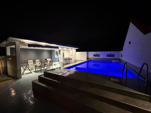 a swimming pool at night with a table and chairs at Villa Mešić in Stojčevac