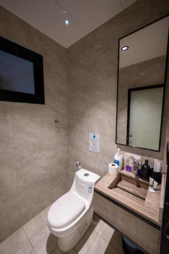 a bathroom with a toilet and a large mirror at استديو خاص in Al Khobar