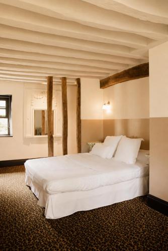 a bedroom with a large white bed in a room at La Dime de Giverny - Chambres d'hôtes-Spa-Restaurant in Giverny
