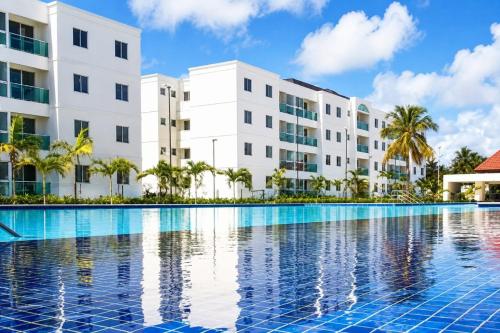 a swimming pool in front of a building at Lindo apartamento em Muro Alto, Porto de Galinhas, Vista para as piscinas, 3 qtos e sala climatizados, Acomoda até 8 pessoas in Ipojuca