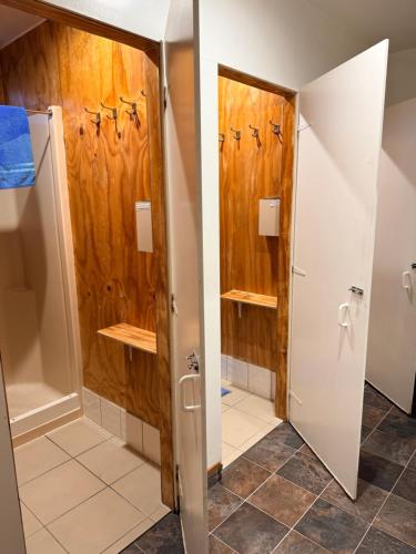 a bathroom with wooden walls and a shower stall at Zula Lodge in Wanaka