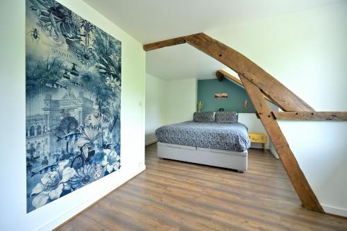 a bedroom with a bed and a mural on the wall at Le Nid de Mazerolles in Sucé