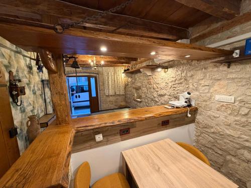 a bar in a room with a stone wall at Studio apartman Ema in Umag