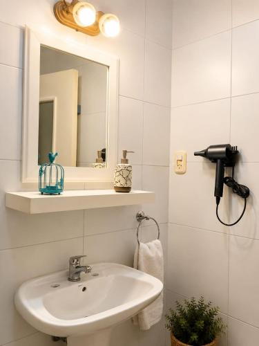 a bathroom with a sink and a mirror at Caelum House Apartamento Con cochera in Rafaela