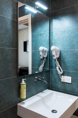ein Badezimmer mit Waschbecken und Spiegel in der Unterkunft Dimora Rosae in Telese