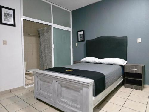 a bedroom with a bed and a bathroom with a shower at 10 VENATOR House Boutique in León