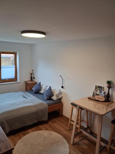 a bedroom with a bed and a table at Ferienwohnung Schneckenpointner in Waging am See