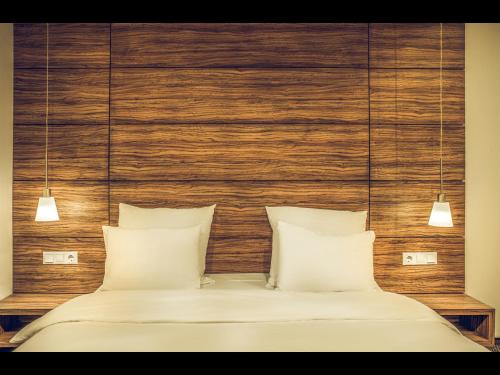 a bedroom with two white pillows and a wooden headboard at Hotel Oscar in Campina