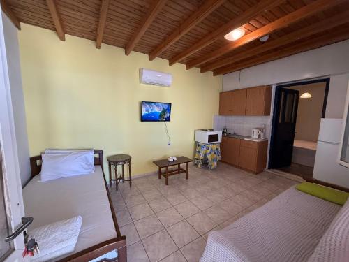 a room with a bed and a kitchen in it at Yellow Beach House in Logaras
