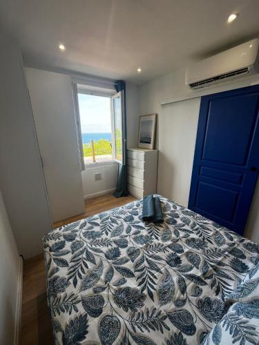 a bedroom with a bed with a blue door and a window at Casa Mediterraneo - Vue mer 3 min de la plage à pieds in Cap d'Ail