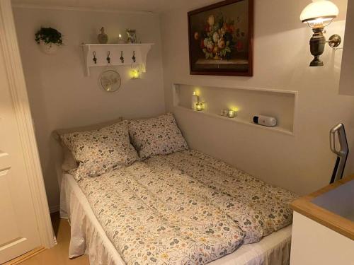 a bed in a bedroom with candles on the wall at Elf's Cottage in Vatnsoyrar