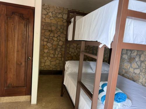 a bunk bed room with two bunk beds and a door at Del Mar Beach House in Nimá