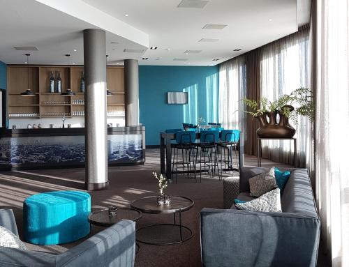 a living room with blue walls and a table and chairs at Van der Valk Hotel Groningen-Hoogkerk in Groningen