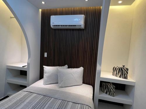 a small bedroom with a bed and a air conditioner at Loft Rome Nacosari in Aguascalientes