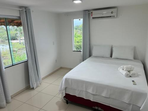 a bedroom with a bed with two towels on it at El Shaday Suítes - ATÍNS in Atins
