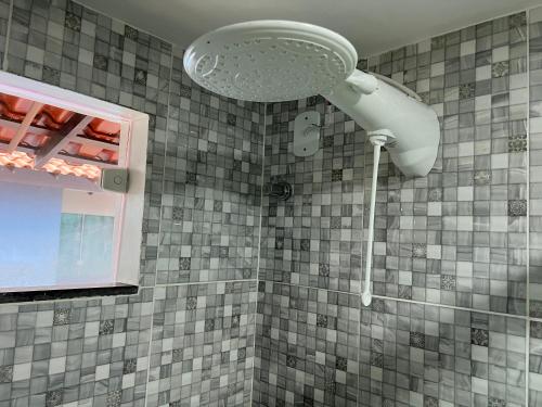 a shower with a shower head in a bathroom at El Shaday Suítes - ATÍNS in Atins