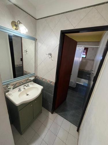 a bathroom with a sink and a mirror and a shower at Cabañas Las Lomas in Juana Koslay 