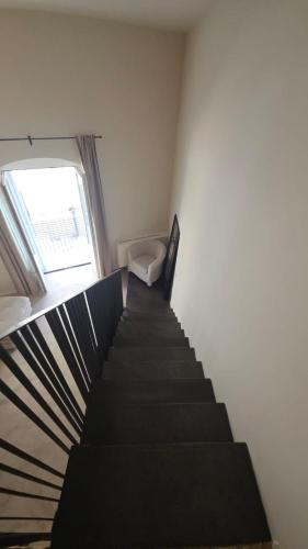a staircase in a room with a chair and a window at La Pietra - Bari Vecchia, Vista Mare in Bari