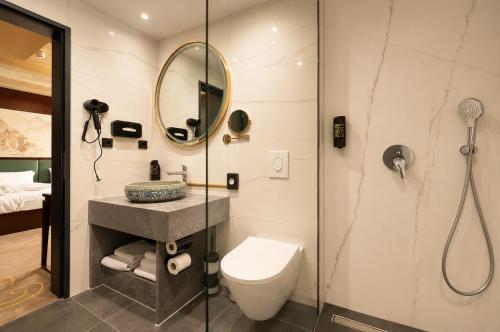 a bathroom with a shower and a toilet and a mirror at Olive INN Berlin in Berlin