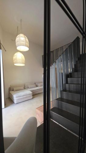 a living room with a staircase and a couch at La Pietra - Bari Vecchia, Vista Mare in Bari