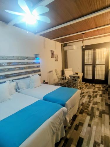 a bedroom with two beds and a table and chairs at "La Güena Vida" Chalet con 4 Habitaciones de Hotel in Algodonales
