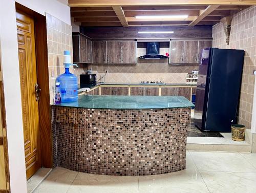 a kitchen with a counter with a bottle of water on it at The Valley View Pent House in Murree