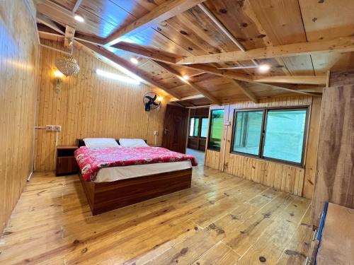 a bedroom with a bed in a room with wooden floors at The Valley View Pent House in Murree