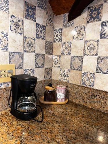 a coffee maker on a counter in a kitchen with tiles at Chalé Coração de Monte Verde in Monte Verde