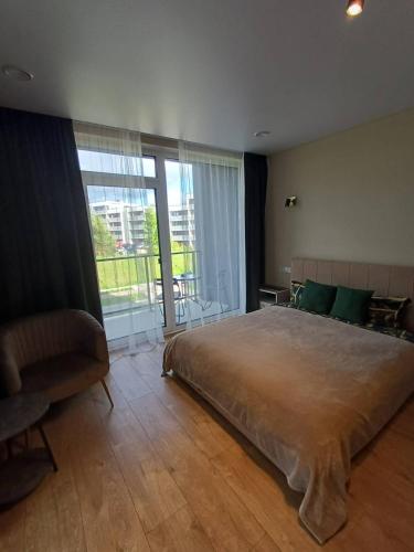 a bedroom with a large bed and a large window at Labaresto Plaza jums in Vilnius