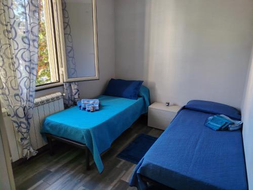 a small room with two beds and a window at Sweet Home in Oliveri