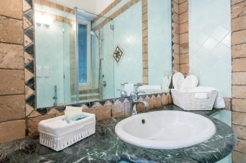 a bathroom with a sink and a large mirror at Villa Preziosa - Panoramic Sea View in Capri