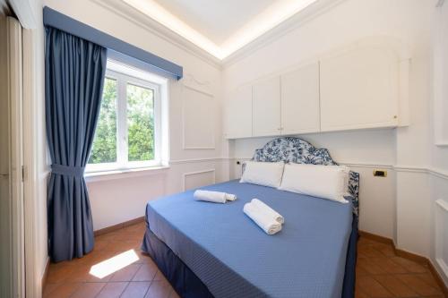 a bedroom with a blue bed with two towels on it at Villa Preziosa - Panoramic Sea View in Capri