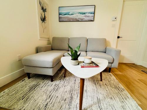 a living room with a couch and a table at Your Cozy NL Haven in St. John's