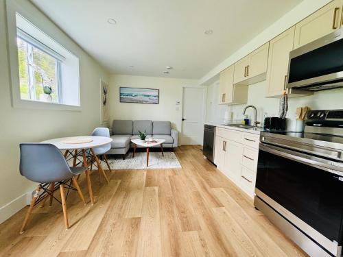 a kitchen and living room with a table and chairs at Your Cozy NL Haven in St. John's
