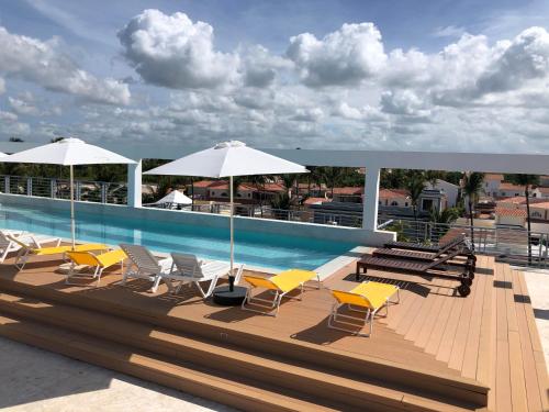 a group of chairs and umbrellas next to a swimming pool at DUKASI ESCAPE playa LOS CORALES in Punta Cana