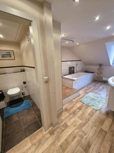 a bathroom with a tub and a toilet and a sink at Ferienwohnung NORA - direkt am Bodensee in Friedrichshafen