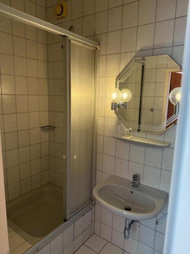 a bathroom with a shower and a sink and a mirror at Campus Hotel - ehemals Hotel Paseo in Aachen