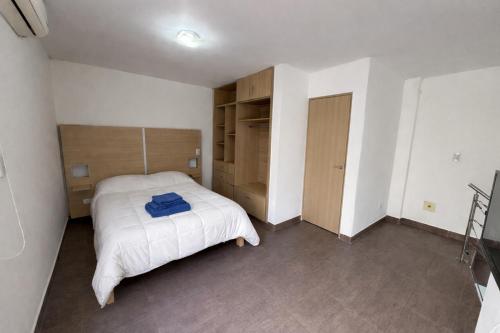 a bedroom with a white bed and a closet at Cabañas Aires del Bosque in Santa Teresita