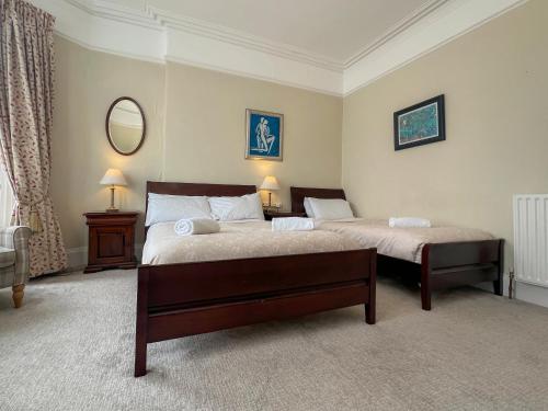 a bedroom with two beds and a mirror at Somerton House Rooms Only in Belfast
