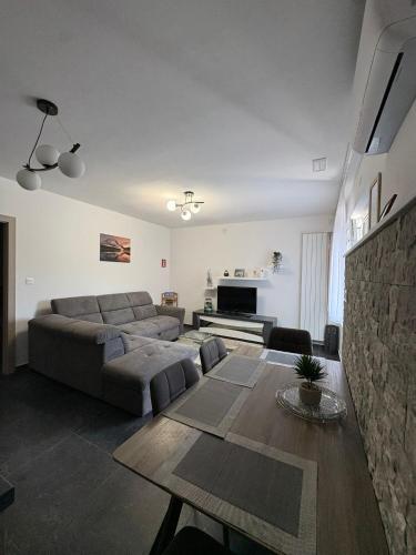 a living room with a couch and a table at Apartmani HeManoS in Duga Resa