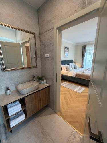 a bathroom with a sink and a bedroom with a bed at Heritage Villa Francheza-Elegant Stone villa near the Beach, Pašman Island , Ugrinić in Ugrinići