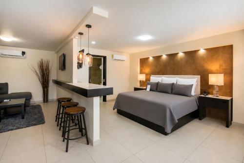 a bedroom with a bed and a living room at Hotel Cortez Baja Inn, Ensenada in Ensenada