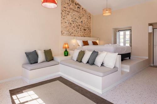 a bedroom with a white bed and a couch at Casas dos Amigos in Bom Sucesso