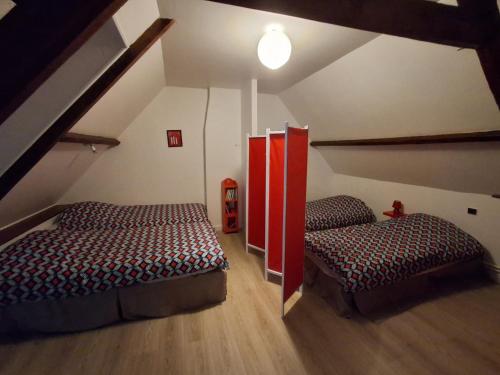 a attic room with two beds and a staircase at Le gite des Menhirs in Mont-Saint-Éloi